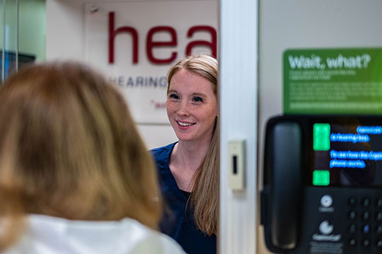 Patient care coordinator greets a hearing aid patient.