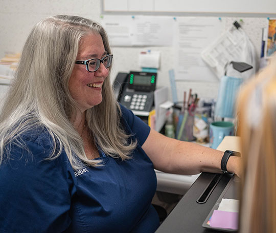 A patient care coordinator at her desk