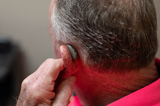 Close up of man wearing a hearing aid.